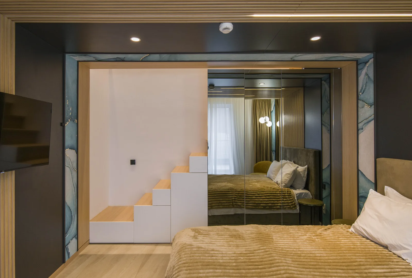 Integrated staircase to the mezzanine, with a mirror wall reflecting the bed, Family Room MAPAMONT Văliug