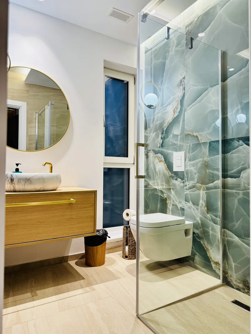 Bathroom with marble washbasin, golden taps and a shower with an onyx wall, VIP Room MAPAMONT Văliug