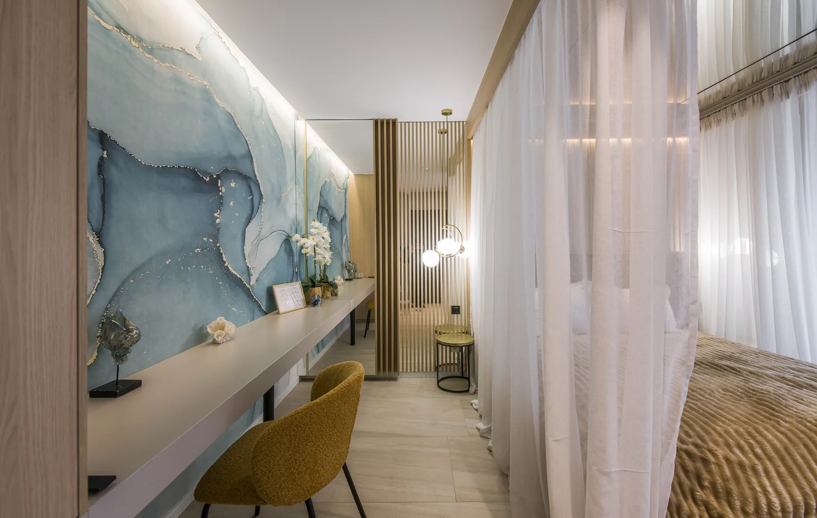 Long desk with a wall of blue-toned natural stone, golden accents and a large mirror, VIP Room MAPAMONT Văliug