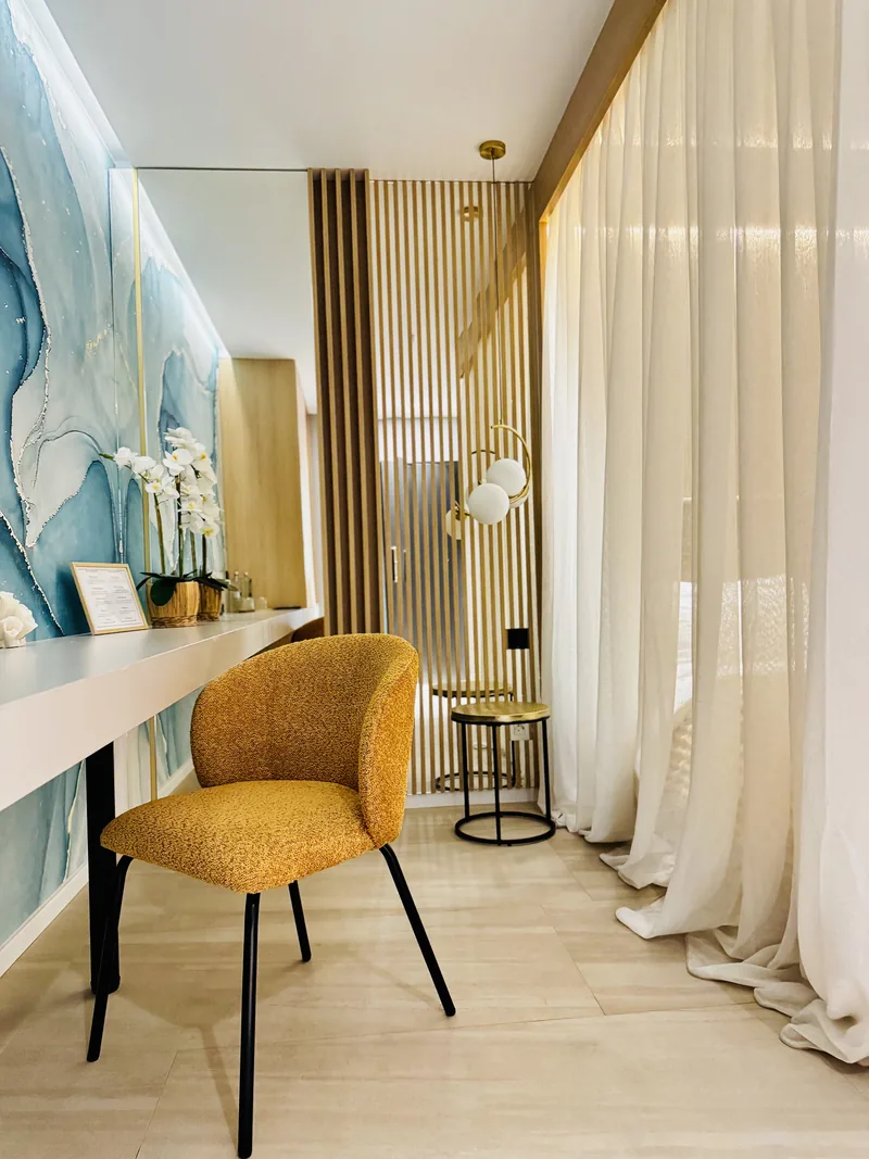 Desk with a wall of blue-toned natural stone, upholstered chair and orchid, VIP Room MAPAMONT Văliug
