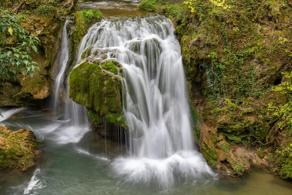 The waters of the Bigăr Waterfall trickling over the green moss dome, Caraș-Severin