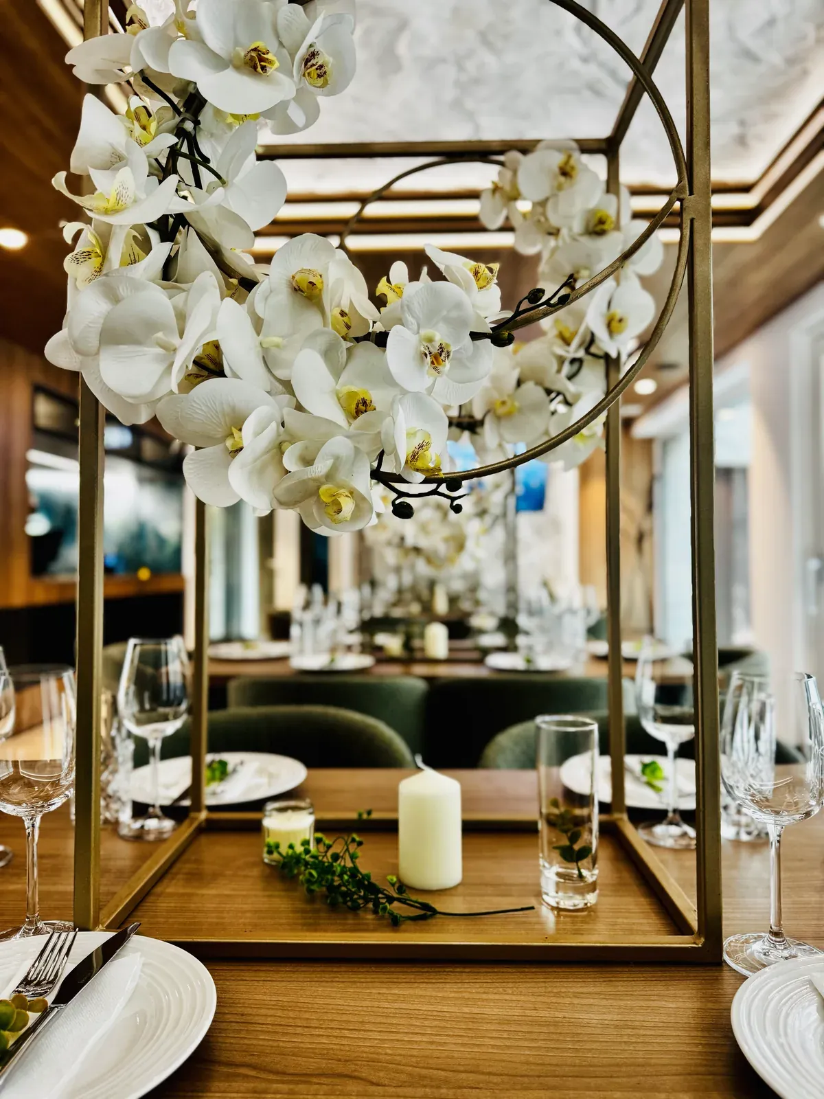 Aranjament cu orhidee albe pe o masă festivă în restaurantul MAPAMONT din Văliug
